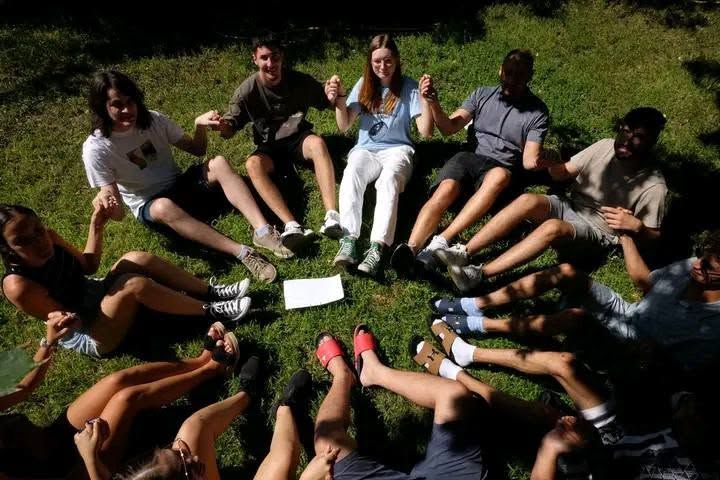 Young people sitting in a circle on the grass
